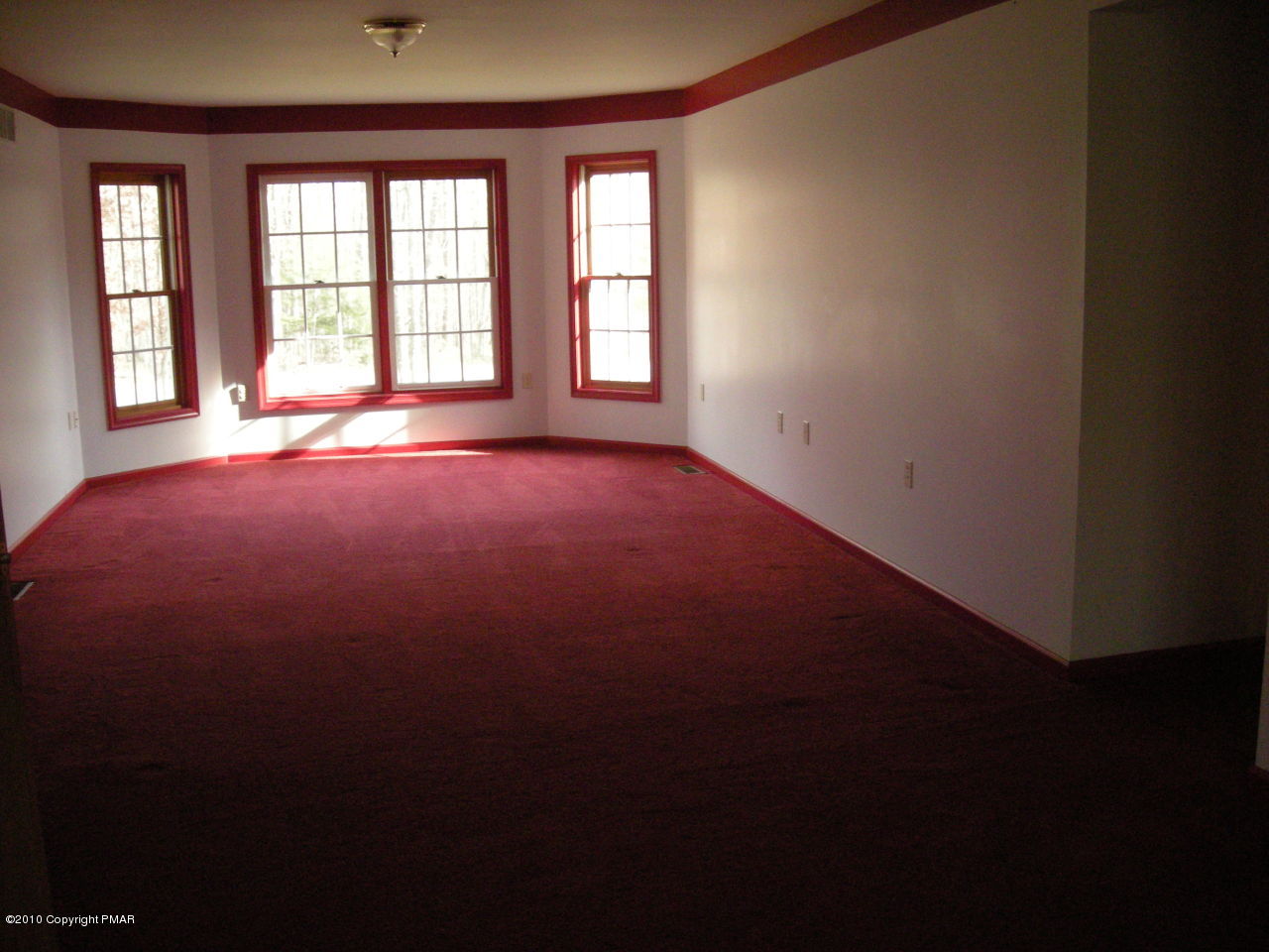 719 Dancing Ridge Road East Stroudsburg, PA 18302 - Photo 8 of 12 an empty room with a fireplace and windows