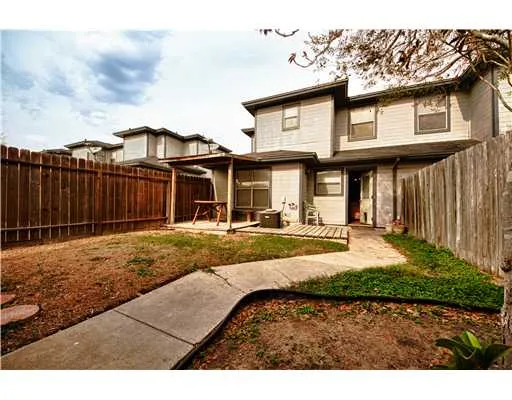 a view of a house with backyard and wooden fence