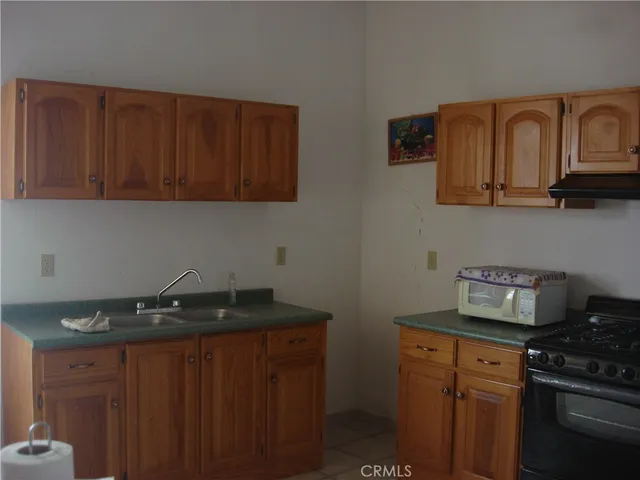 a kitchen with granite countertop stainless steel appliances a stove a sink and dishwasher
