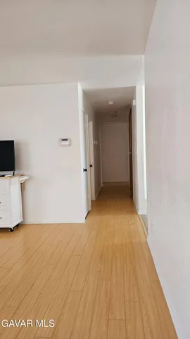 a view of a room with wooden floor and white walls