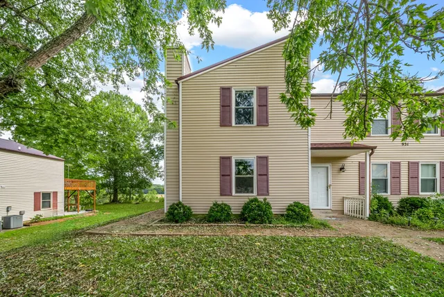 a front view of a house with a yard and trees