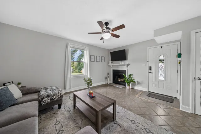 a living room with furniture a fireplace and a window