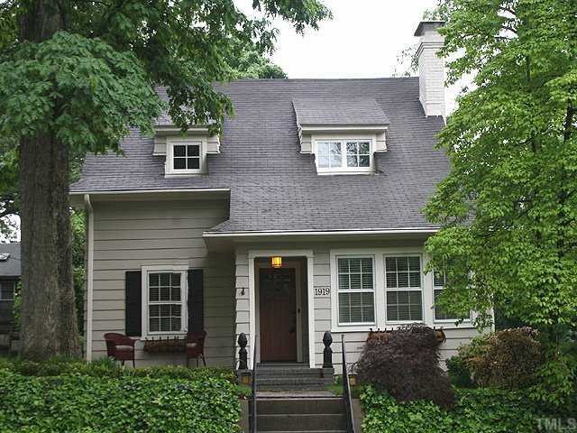 1919 Sunset Drive Raleigh, NC 27608 - Photo 1 of 12 a view of a brick house with a large windows and a large tree