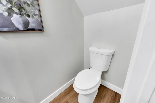 a white toilet sitting next to a white wall