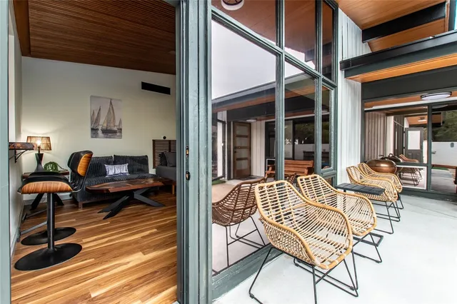 a living room with patio furniture and a wooden floor
