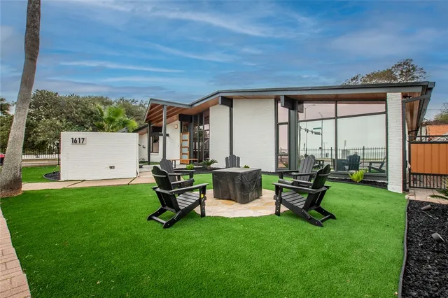 a view of a backyard with a garden and chairs
