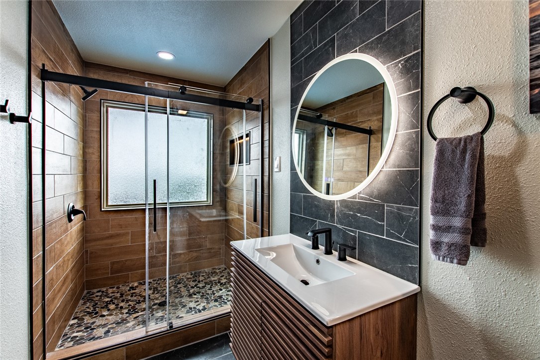 1617 Ocean Drive Corpus Christi, TX 78404 - Photo 39 of 40 a bathroom with a sink a mirror a vanity and shower