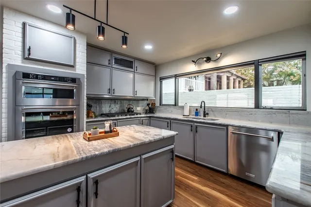 a kitchen with stainless steel appliances granite countertop a stove sink and cabinets