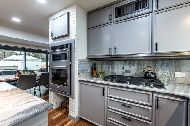 a kitchen with stainless steel appliances granite countertop a stove and a refrigerator