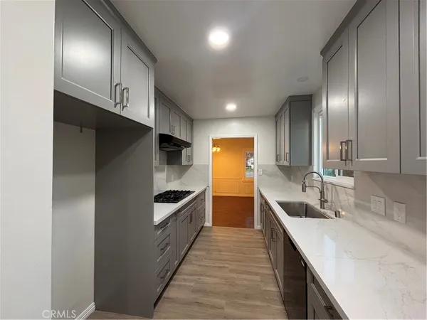 a kitchen with stainless steel appliances granite countertop a sink and a refrigerator