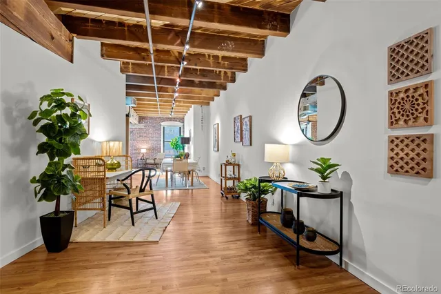 a dining room with furniture potted plants and wooden floor