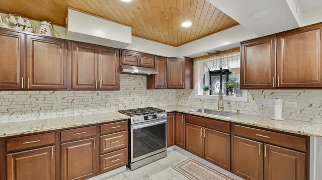 a kitchen with stainless steel appliances granite countertop a sink stove and cabinets