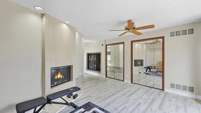 a view of a livingroom with wooden floor and a fireplace
