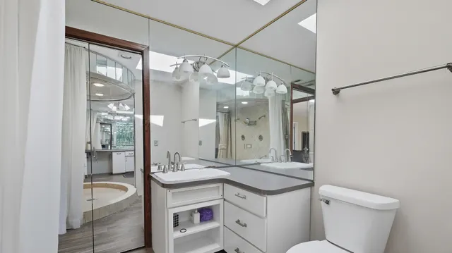 a bathroom with a granite countertop sink toilet a mirror and shower