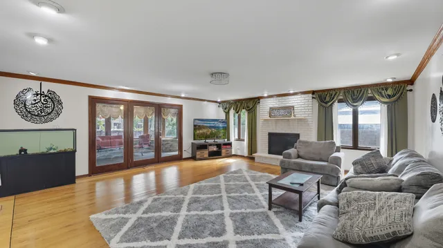a living room with furniture large window and wooden floor