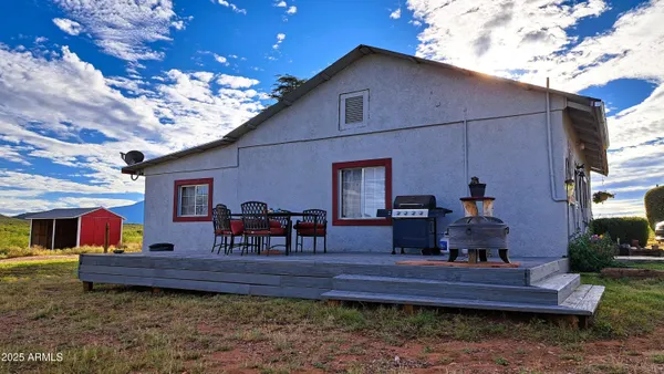a view of a house with wooden deck and furniture