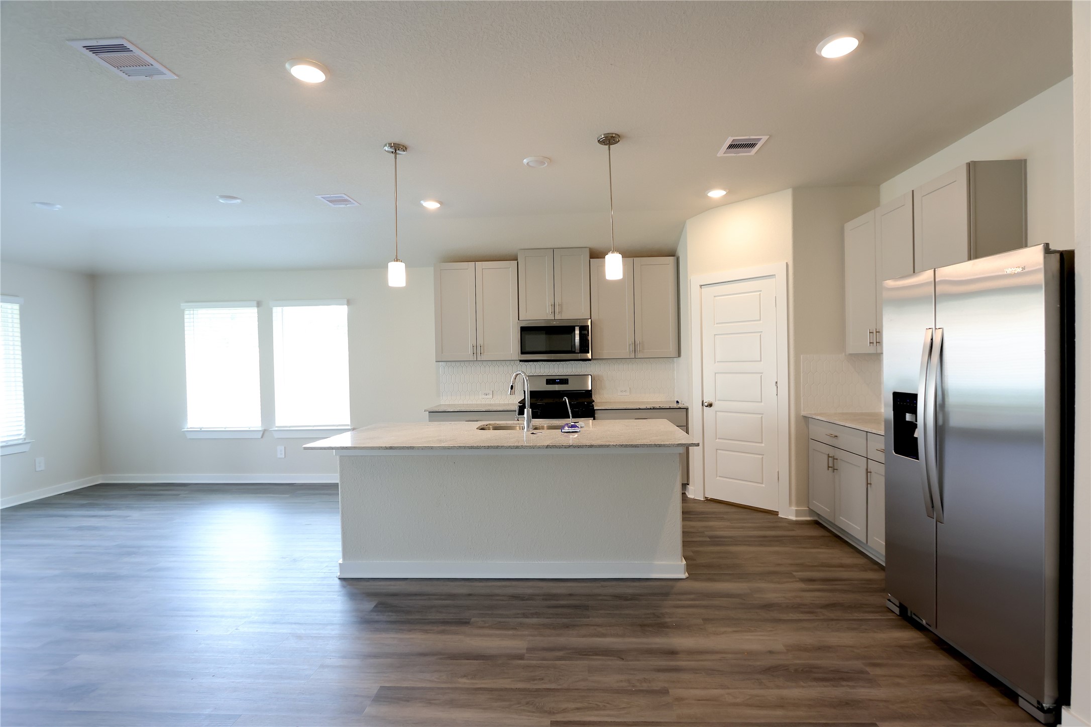 1435 Waggoner Rnch Trail Conroe, TX 77301 - Photo 8 of 17 a view of kitchen with stainless steel appliances granite countertop a stove top oven a refrigerator a sink and dishwasher with wooden floor