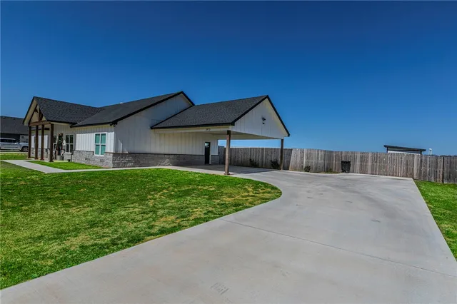a living room with furniture kitchen view and a wooden floor