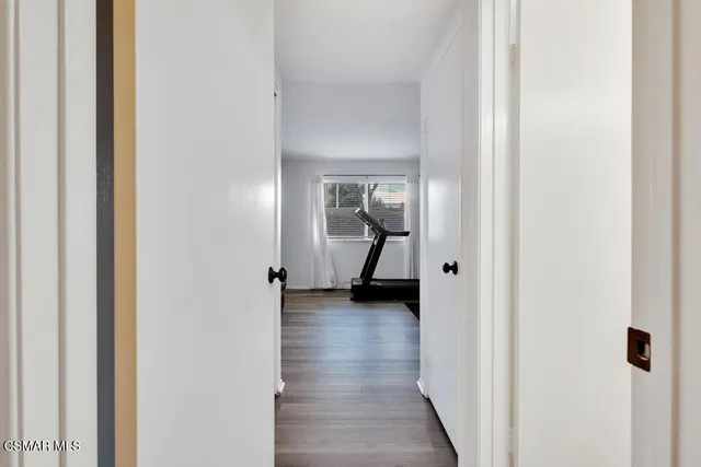 a view of a hallway with wooden floor