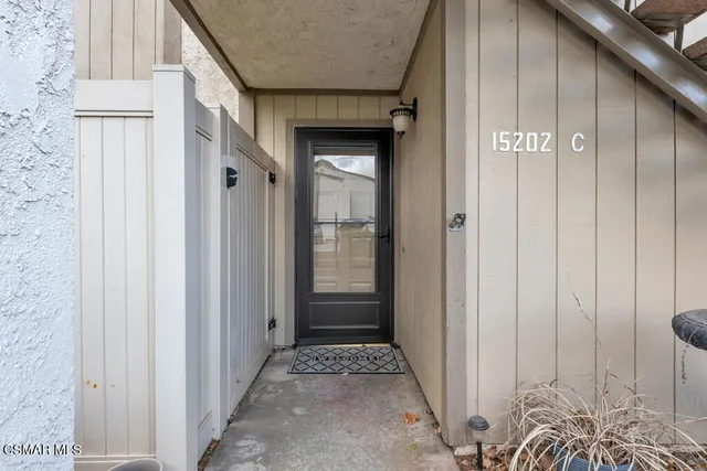 a view of a hallway with wooden floor and a door