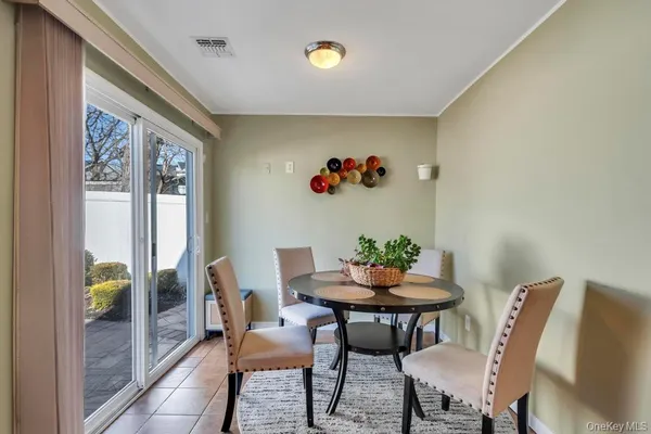 a dining room with furniture and a potted plant