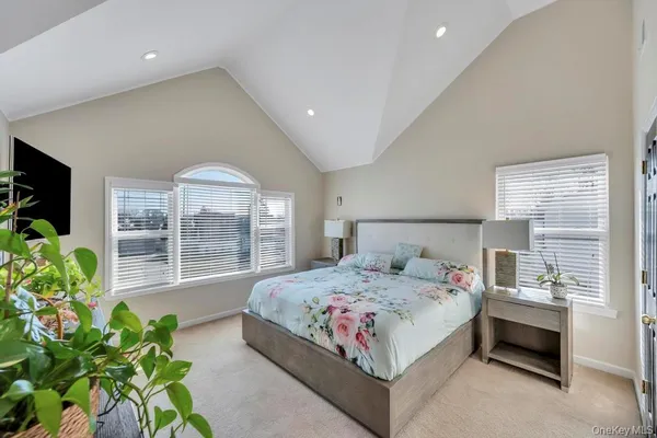a bedroom with a bed mirror and window