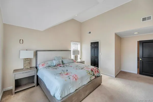 a bedroom with a bed and a refrigerator