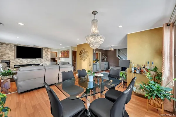 a view of a dining room with furniture a kitchen and chandelier