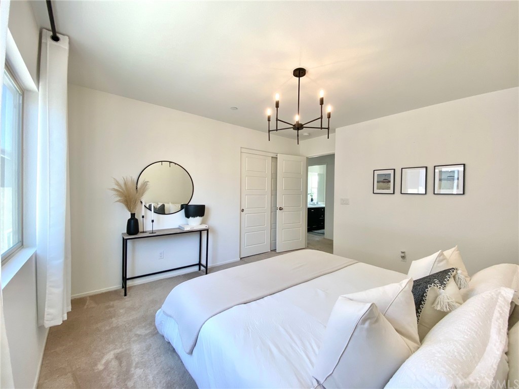 858 Blue Orchid Beaumont, CA 92223 - Photo 15 of 33 a bedroom with a bed and chandelier