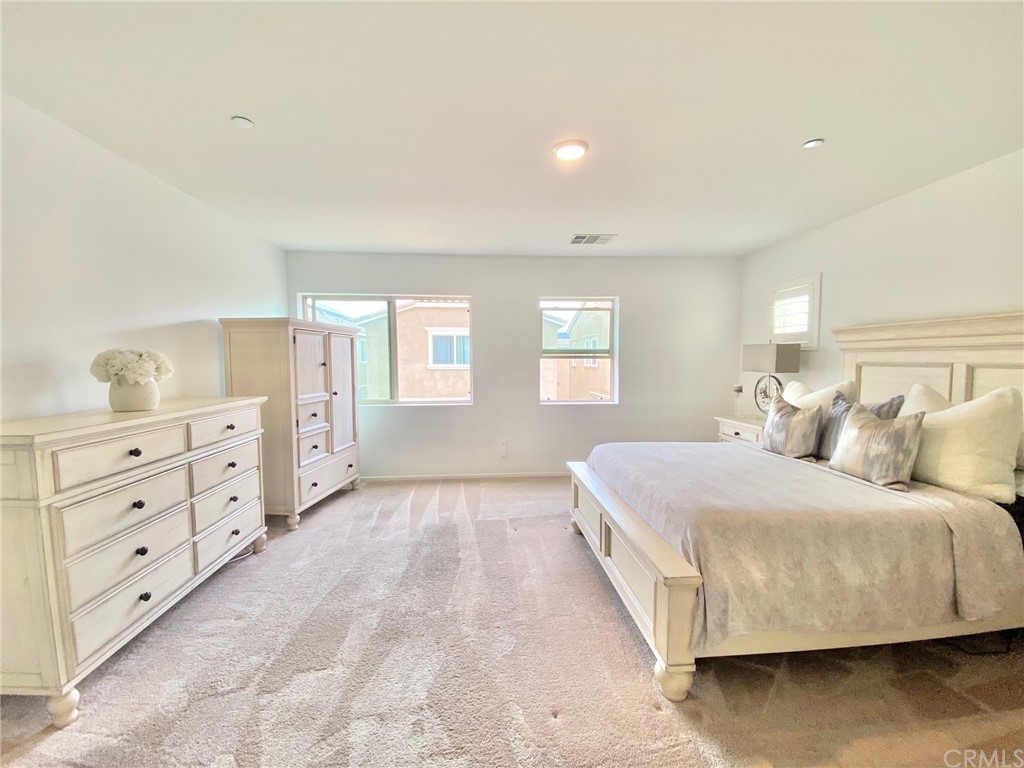 858 Blue Orchid Beaumont, CA 92223 - Photo 22 of 33 a bedroom with a bed and a dresser