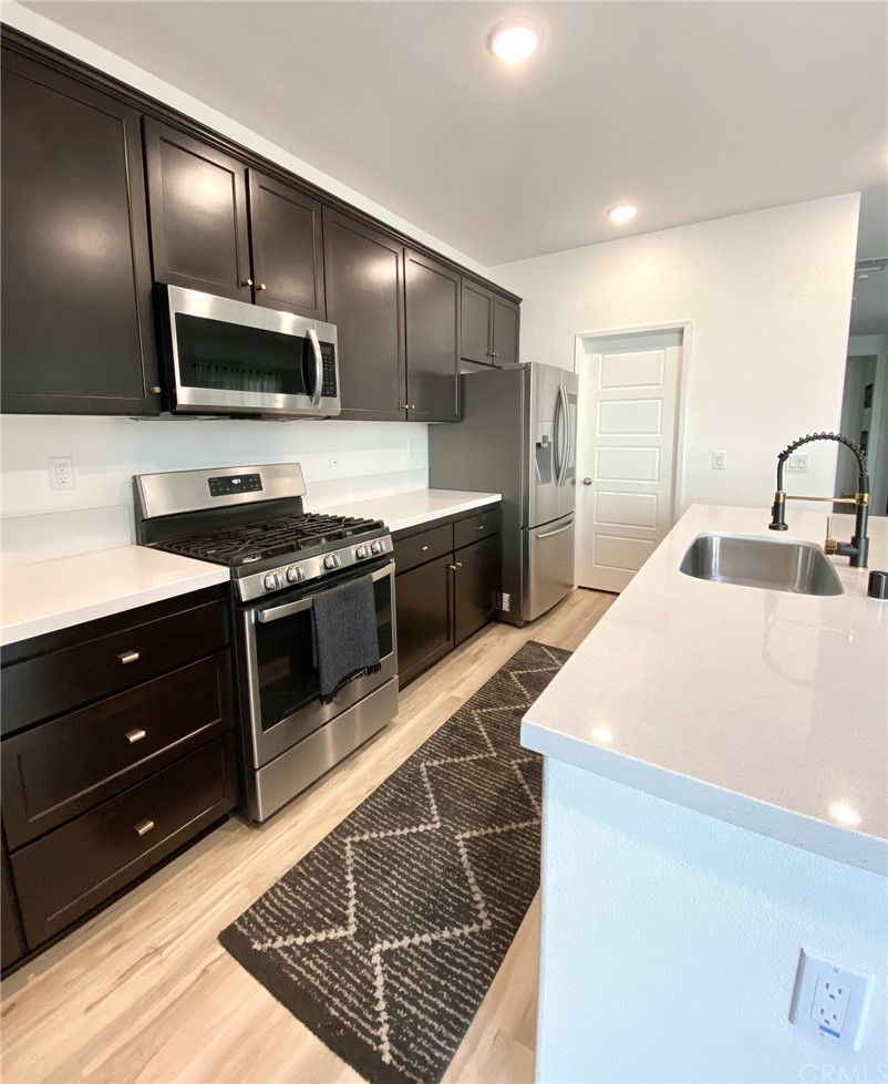 858 Blue Orchid Beaumont, CA 92223 - Photo 7 of 33 a kitchen with stainless steel appliances granite countertop a sink stove and oven