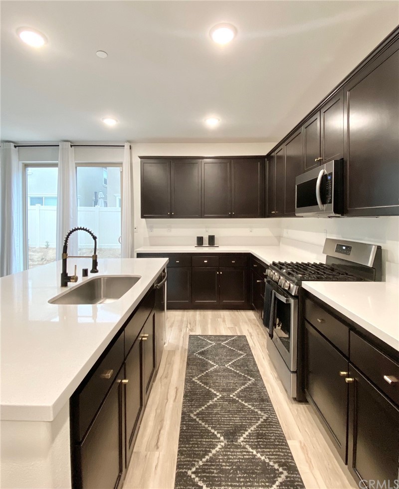 858 Blue Orchid Beaumont, CA 92223 - Photo 8 of 33 a large kitchen with a stove and a sink