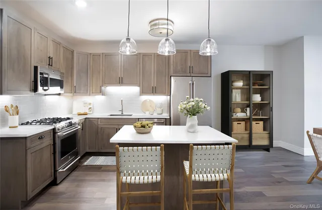 a kitchen with granite countertop a stove a sink dining table and chairs