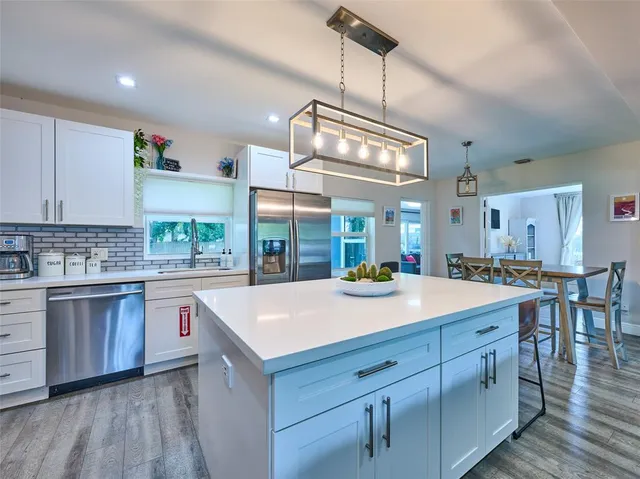 a kitchen with a stove a window and chairs