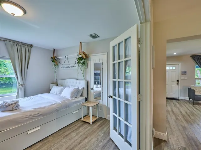 a bedroom with a large bed and a flat tv screen on dresser