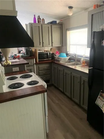 a kitchen with kitchen island granite countertop a sink stainless steel appliances a window and a counter