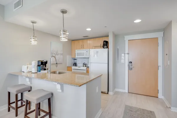 a kitchen with kitchen island white cabinets and refrigerator