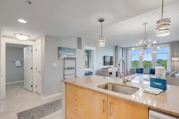 a kitchen with granite countertop a sink cabinets and stainless steel appliances
