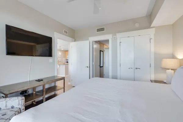 a spacious bedroom with a bed and a flat screen tv