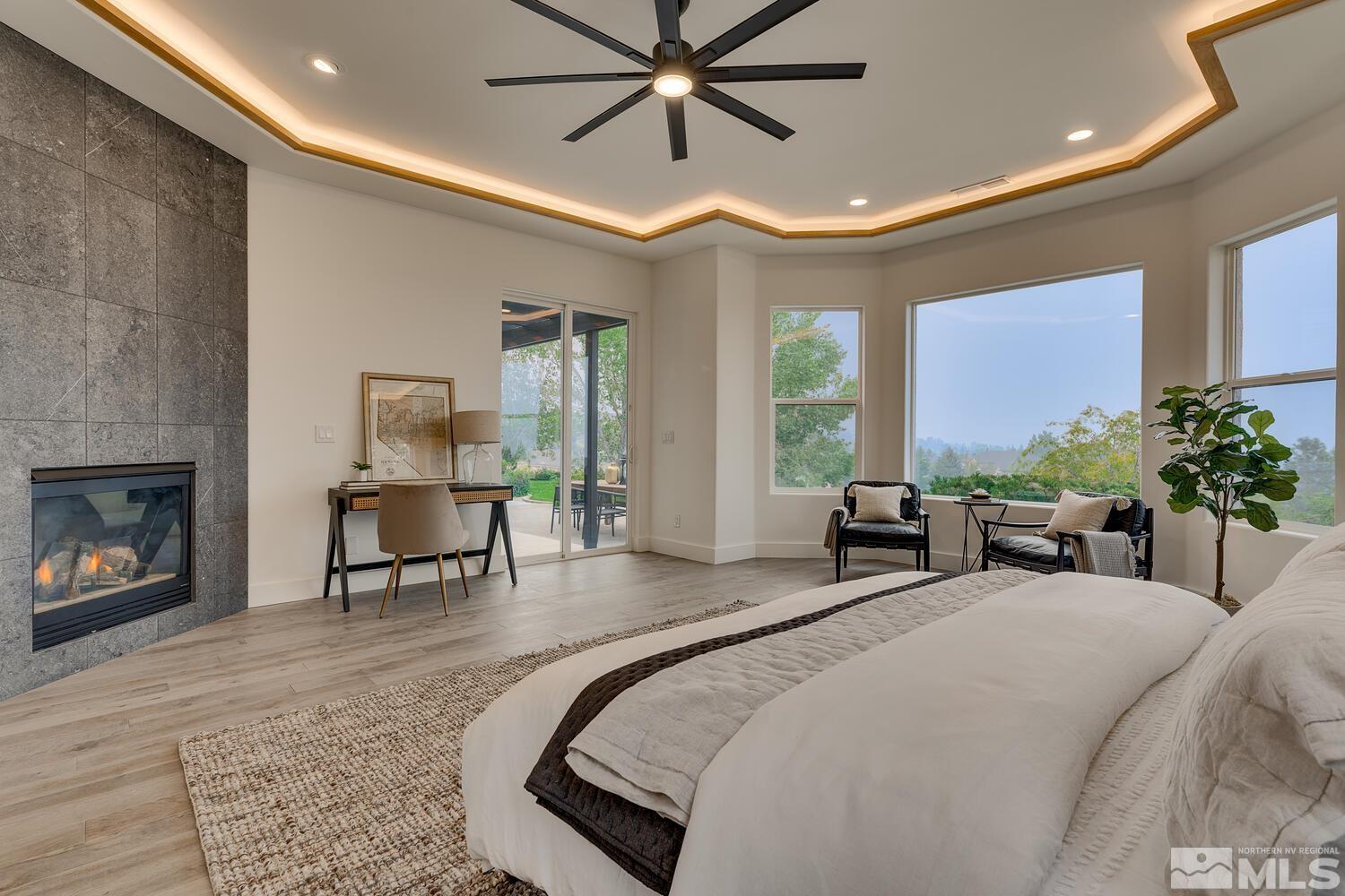 6109 Mesa Road Reno, NV 89511 - Photo 15 of 40 a spacious bedroom with a bed a table and a chandelier