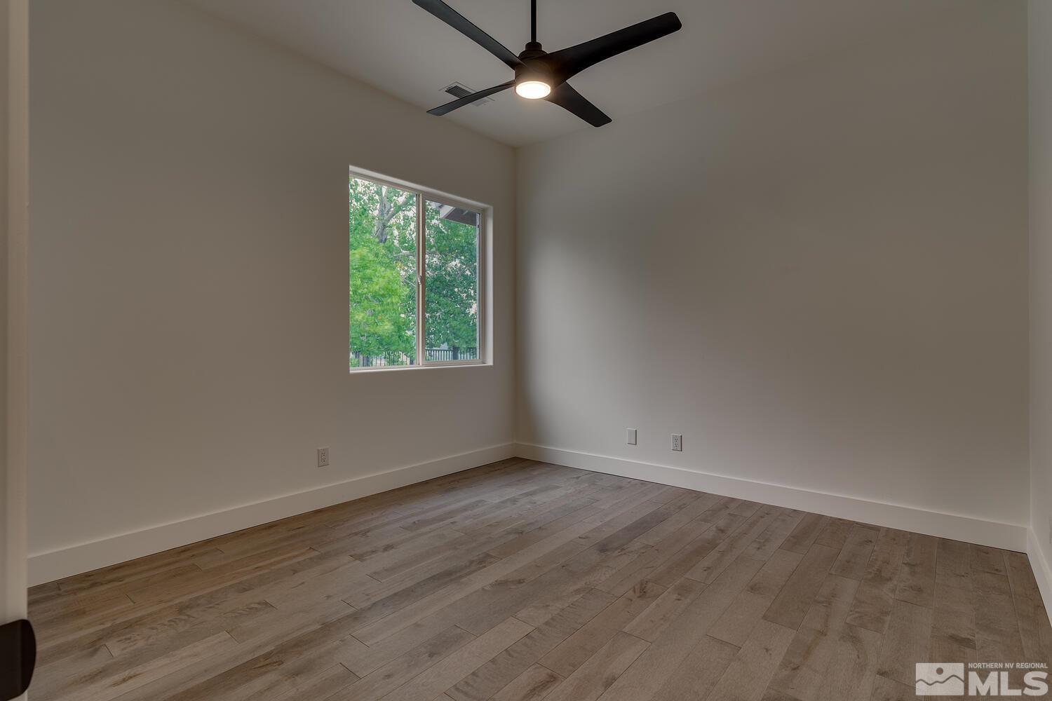 6109 Mesa Road Reno, NV 89511 - Photo 20 of 40 an empty room with wooden floor chandelier fan and windows