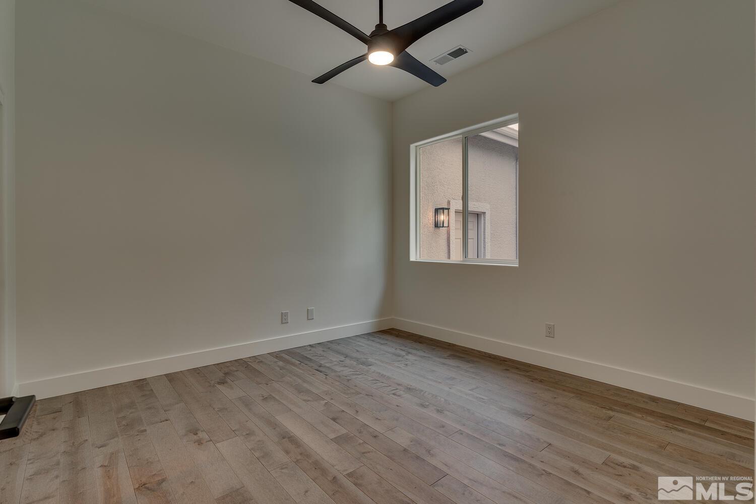 6109 Mesa Road Reno, NV 89511 - Photo 22 of 40 an empty room with wooden floor chandelier fan and windows