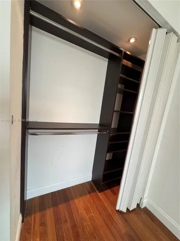 a view of walk in closet with wooden floor