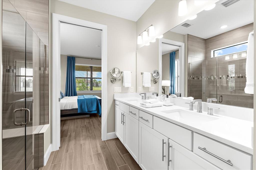 6791 Alstead Circle Lakewood Ranch, FL 34202 - Photo 6 of 25 a en suite bathroom with a double vanity sink a mirror and a shower