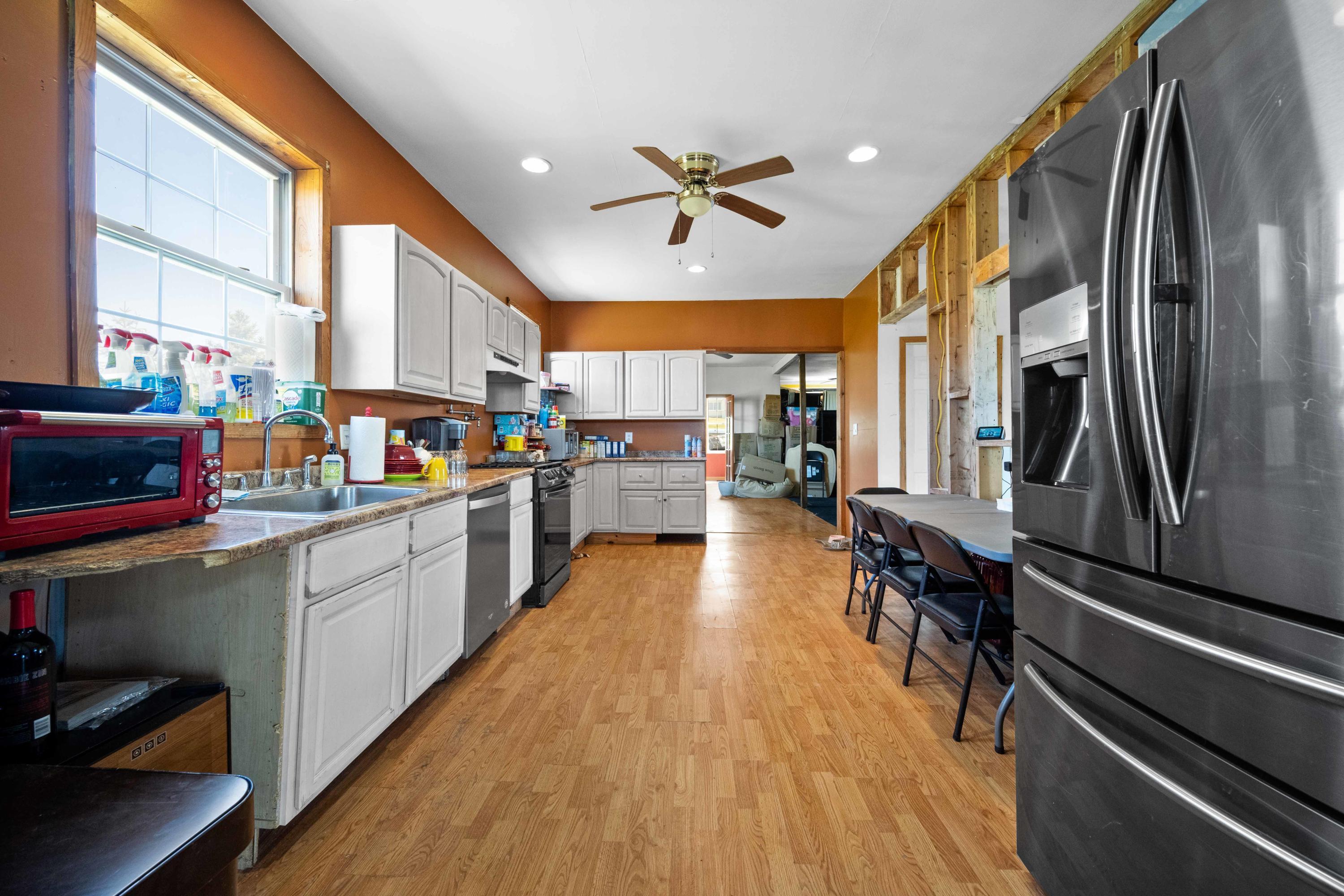 1571 State Rte 2016 Nicholson, PA 18446 - Photo 11 of 28 a kitchen with stainless steel appliances a refrigerator a sink dishwasher a stove and white countertops with wooden floor