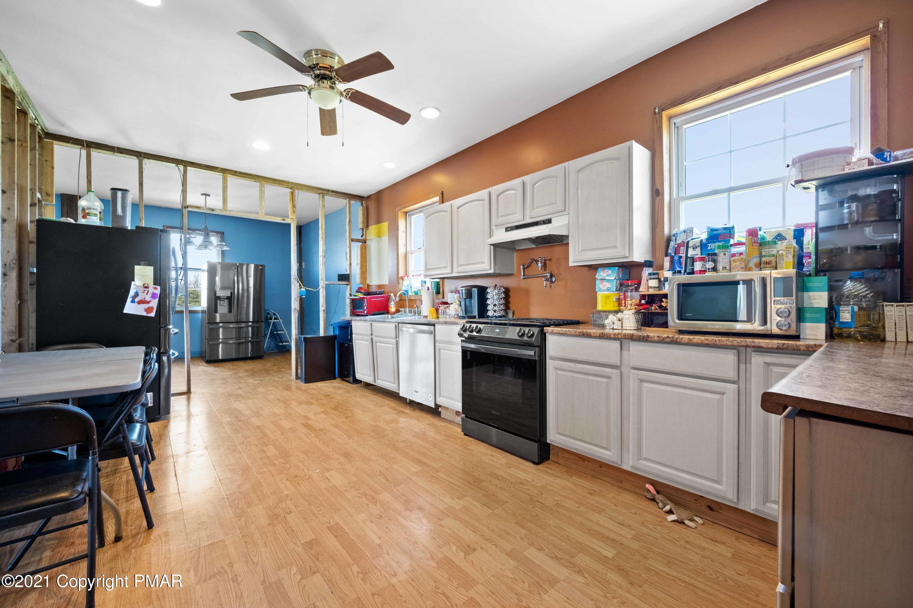 1571 State Rte 2016 Nicholson, PA 18446 - Photo 8 of 28 a kitchen with stainless steel appliances kitchen island granite countertop a refrigerator oven a sink dishwasher and white cabinets with wooden floor