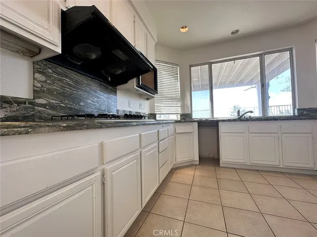 a kitchen with a sink a stove and cabinets
