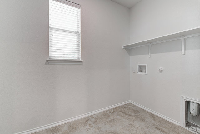 1237 Volente Lane Leander, TX 78641 - Photo 8 of 22 Functional utility room with ample natural light and convenient shelving for storage.
