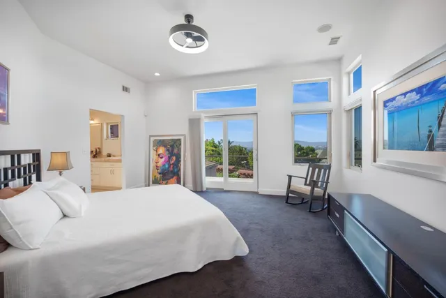 a spacious bedroom with a large bed and a large window