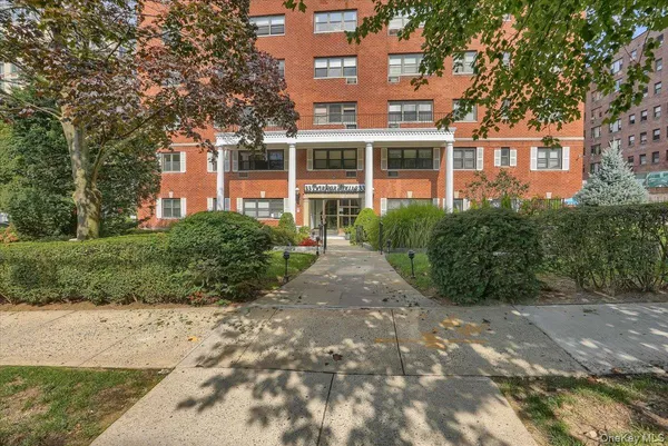 a front view of a building with a garden
